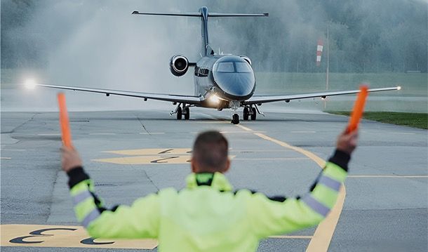 PVJets private jet on the apron with a ground marshaller