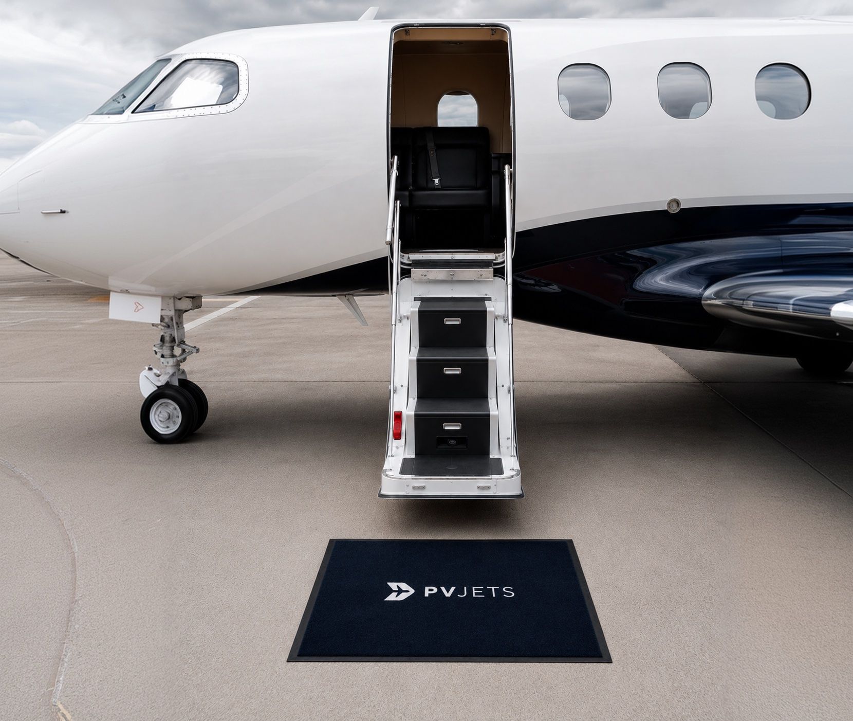 PVJets private jet with a branded stair mat
