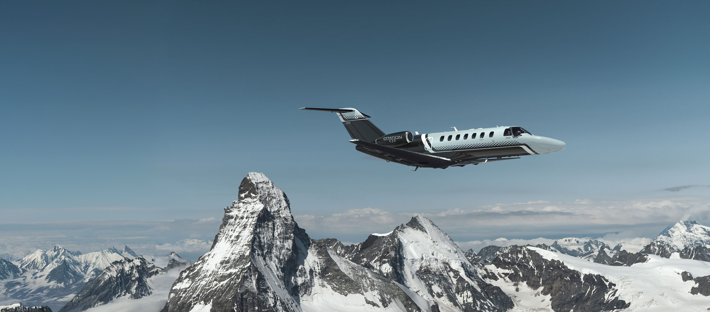 Light Jet im Flug über schneebedeckten Bergen