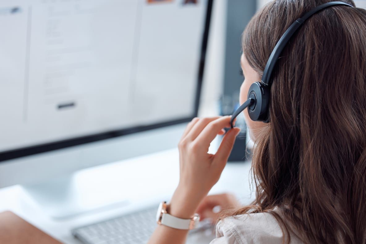 PVJets Beraterin für Privatluftfahrt mit Headset an ihrem Arbeitsplatz