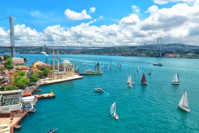 Aerial view of the Bosphorus Bridge and Ortaköy Mosque, with sailboats crossing the strait