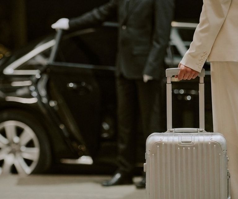 Chauffeur verstaut Gepäck in einer Luxuslimousine