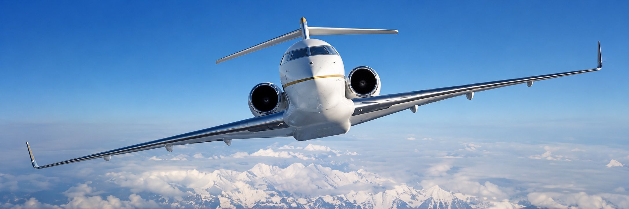 Privatjet im Flug über schneebedeckten Bergen unter blauem Himmel
