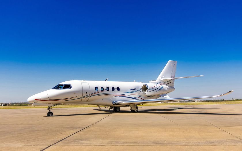 Jet privé Cessna Citation Latitude stationné sur un tarmac ensoleillé sous un ciel bleu profond