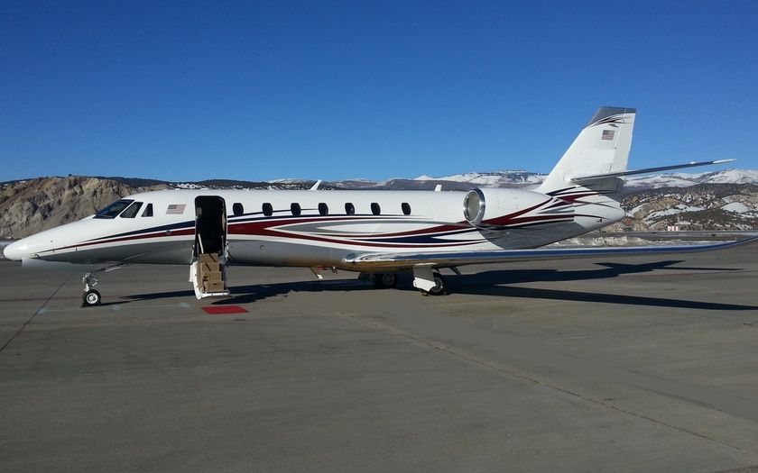 Cessna Citation Sovereign+ private jet parked on the apron with snow-capped mountains in the background