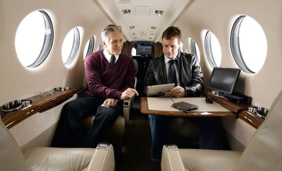 Business traveller working on a laptop aboard a private jet