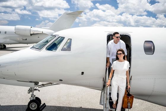 Couple walking towards a private jet in a mountain setting