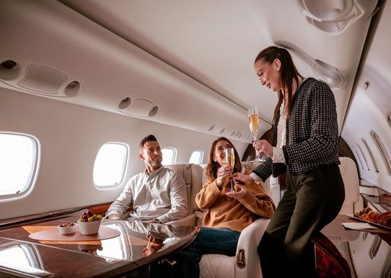 Group of travellers enjoying champagne aboard a private jet