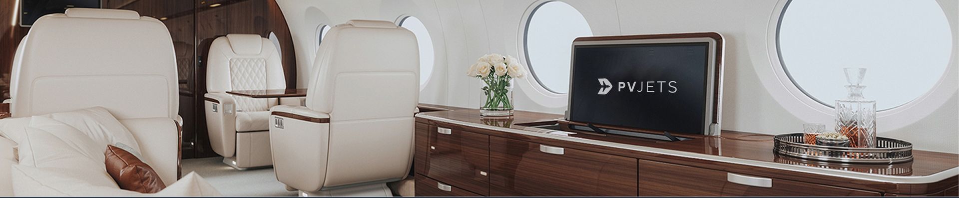 Luxurious private jet cabin with the PVJets logo on the screen