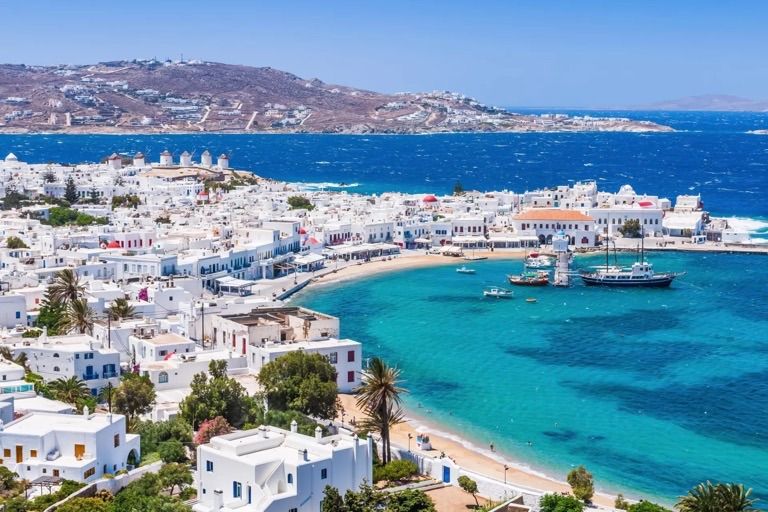 Il centro bianco di Mykonos sopra il porto vecchio, con i mulini a vento sulla collina