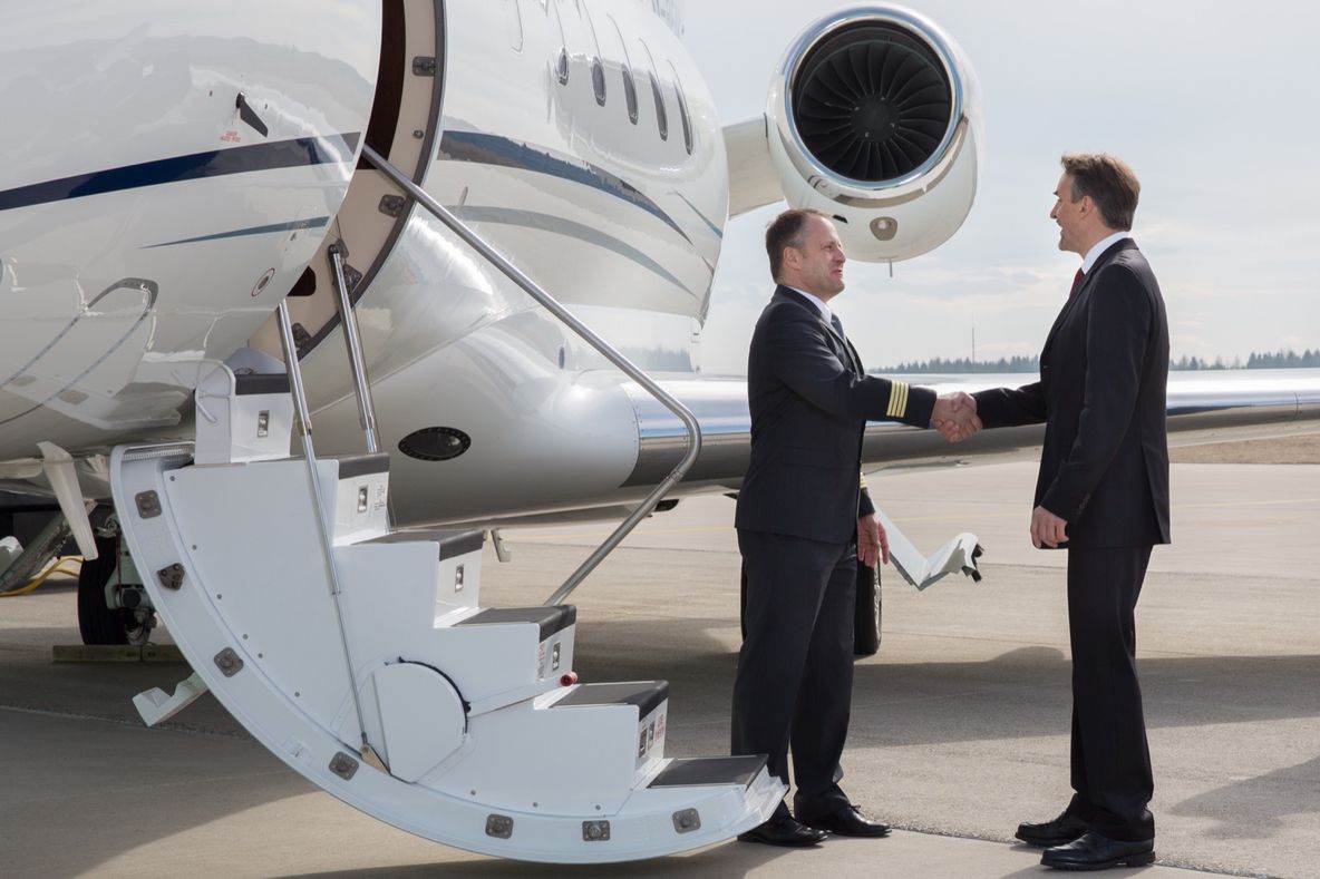 A PVJets captain shaking hands with a client beside a private jet