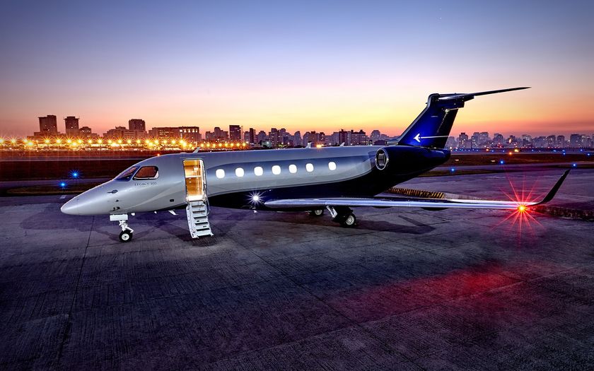 Jet privé Embraer Legacy 500 sur le tarmac au coucher du soleil, passerelle déployée