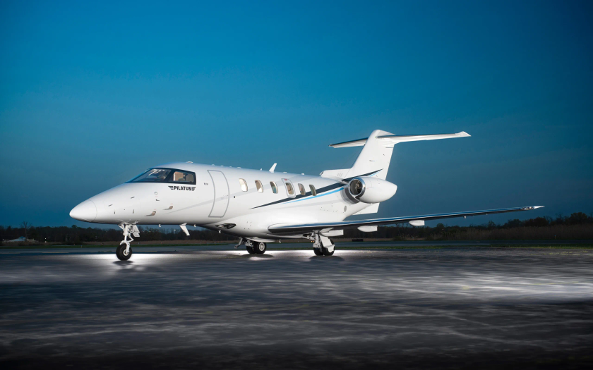 Jet privé Pilatus PC-24 stationné sur un tarmac mouillé au crépuscule