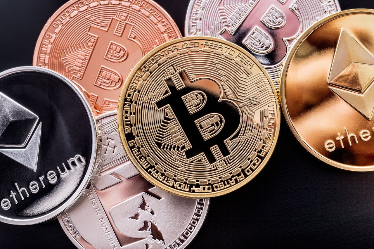 A close-up of cryptocurrency coins, including Bitcoin and Ethereum, on a dark background